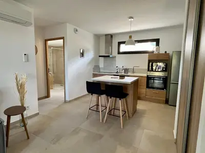 Cuisine ou kitchenette dans l'établissement Appartement climatisé neuf au calme, proche centre-ville, 4 minutes en voiture plage et commerces