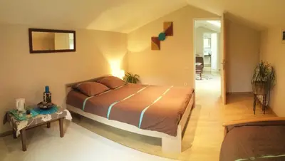 Un ou plusieurs lits dans un hébergement de l'établissement Autour du Hamac chambres et table d'hôtes
