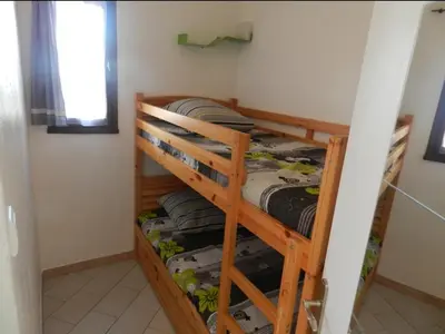 Un ou plusieurs lits superposés dans un hébergement de l'établissement Appartement Vue Mer, piscine, minigolf, parking